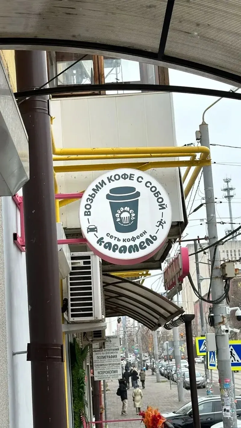 Наружная реклама для кофе с собой: двусторонняя круглая вывеска на фасаде
